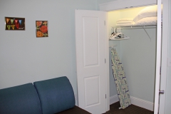 Storage area with iron and ironing board in suite at Third & Main